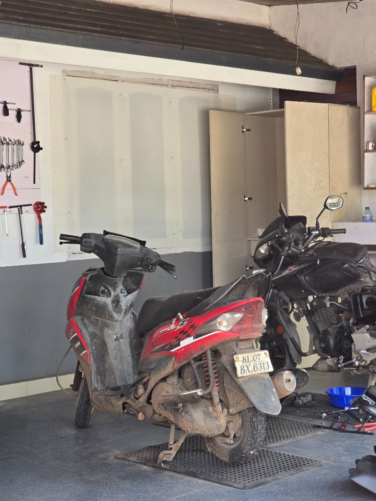 Customer scooters and motorcycles parked inside the workshop for periodic maintenance