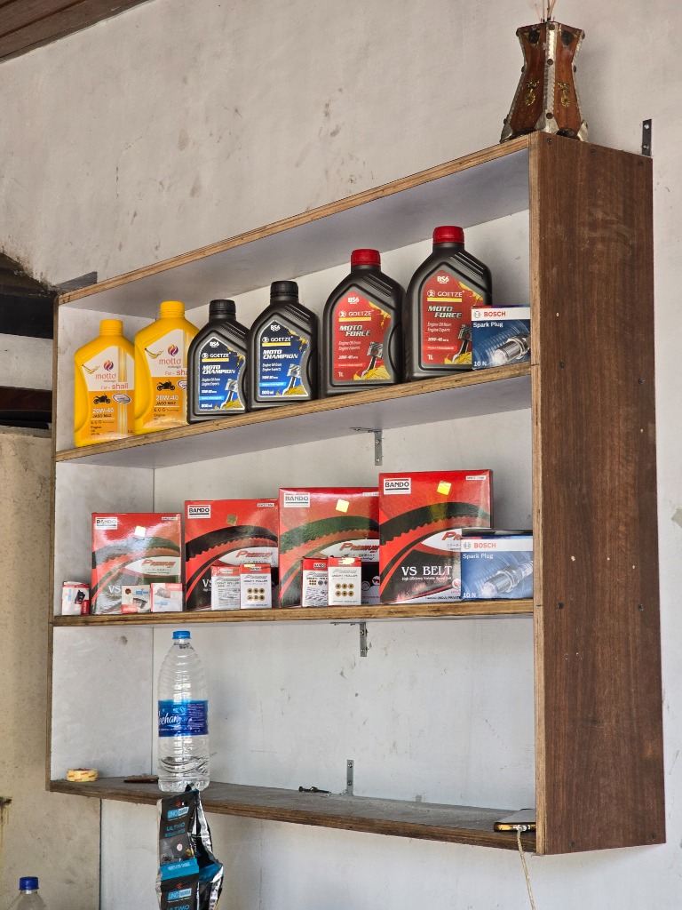Well-stocked shelf with high-grade engine oils, spark plugs, and genuine drive belts